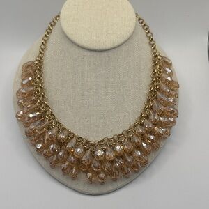 gold-tone chain necklace cascade of peach-colored, faceted glass teardrop beads.